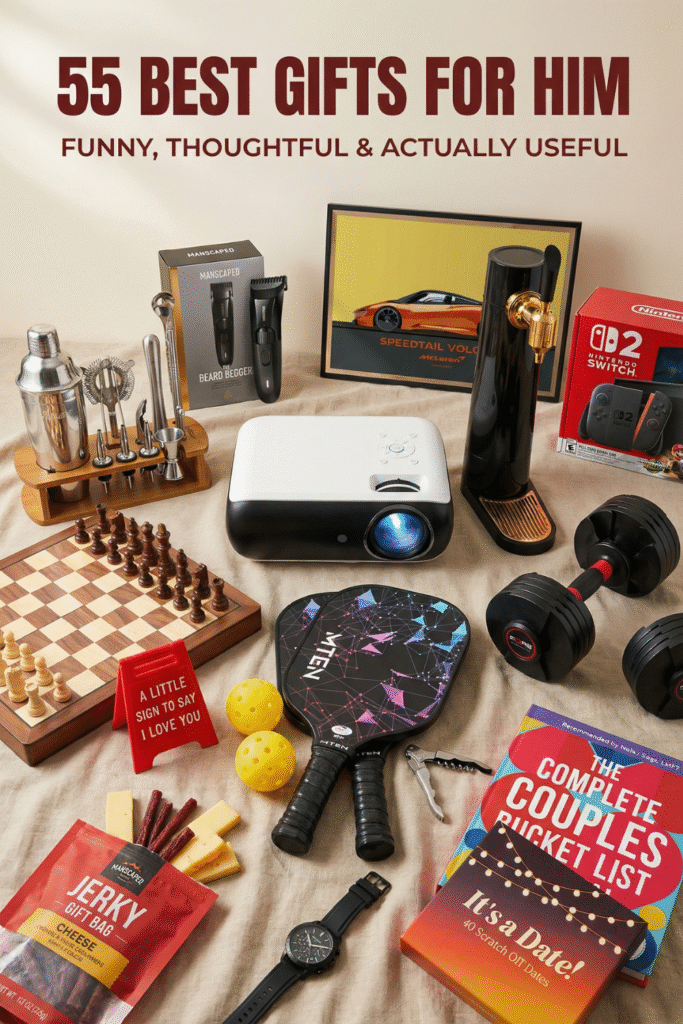 Flat lay of Valentine’s Day gifts for him including tech gadgets, grooming kit, projector, Nintendo Switch, chess board, fitness weights, watch and funny relationship gift books arranged on neutral fabric background.